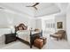 Bright bedroom with a king-size bed, ceiling fan, and cozy sitting area at 8760 Colonial Pl, Duluth, GA 30097