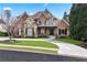 Elegant home with a stone and brick exterior, curved driveway, and manicured lawn at 8760 Colonial Pl, Duluth, GA 30097
