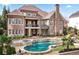 Exterior view of the brick home, showcasing the pool, spa, and landscaped backyard at 8760 Colonial Pl, Duluth, GA 30097