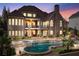 Exterior view of the brick home at dusk, showcasing the pool, spa, and landscaped backyard at 8760 Colonial Pl, Duluth, GA 30097