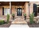 Inviting front entry with stone steps, ornate iron door, and well-manicured landscaping at 8760 Colonial Pl, Duluth, GA 30097
