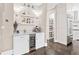 A gourmet kitchen boasts white cabinets, a wine cooler, marble countertops, and stainless steel appliances at 8760 Colonial Pl, Duluth, GA 30097