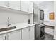 Well-organized laundry room featuring white cabinets, countertop space, and modern washer and dryer at 8760 Colonial Pl, Duluth, GA 30097