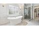 Elegant main bathroom featuring a freestanding tub, glass-enclosed shower, and custom walk-in closet at 8760 Colonial Pl, Duluth, GA 30097