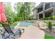 A luxurious in-ground pool with stone accents and a manicured patio area, perfect for outdoor relaxation and entertaining at 8760 Colonial Pl, Duluth, GA 30097
