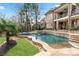 Backyard pool with waterfall feature, stone surround, lush lawn, and landscaping at 8760 Colonial Pl, Duluth, GA 30097