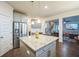 Bright kitchen island with stainless steel refrigerator and an open view to the living room at 1109 Alaska St, Hampton, GA 30228