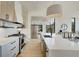 Open kitchen design featuring mixed-tone cabinetry, stainless appliances, floating shelves, and an island with seating at 816 Berne St # 4, Atlanta, GA 30316
