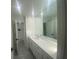 Bright bathroom featuring an extra long vanity, a large mirror, and tiled floors at 145 Amherst Nw Pl, Atlanta, GA 30327