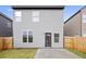 Rear view of the home with a fenced backyard and small patio at 326 Lauren Dr, Fairburn, GA 30213
