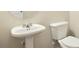 Compact half-bathroom featuring a pedestal sink and toilet with neutral wall paint and simple decor at 326 Lauren Dr, Fairburn, GA 30213