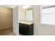 Clean bathroom featuring a vanity with storage, large mirror, and natural light, adjoining a walk-in closet at 326 Lauren Dr, Fairburn, GA 30213