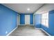 The stylish bedroom features an accent wall, gray flooring, and a window at 3865 Whitney Pl, Duluth, GA 30096