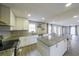 Bright kitchen featuring white cabinets, granite countertops, an island and modern stainless steel appliances at 3865 Whitney Pl, Duluth, GA 30096