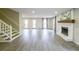 Large open concept living room featuring a fireplace, view to staircase, and double patio doors at 3865 Whitney Pl, Duluth, GA 30096