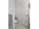 A small bathroom with a toilet and door to an adjacent room at 5546 Wellborn Creek Dr, Lithonia, GA 30058
