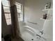 Bright bathroom featuring a bathtub with shower, grab bar, and window for natural light at 5546 Wellborn Creek Dr, Lithonia, GA 30058