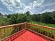 Back deck, great for relaxing, offers a calm view of greenery, and the vibrant red surface adds a pop of color at 5546 Wellborn Creek Dr, Lithonia, GA 30058