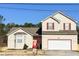Charming two-story home with neutral siding, red accents, and an attached two-car garage at 5546 Wellborn Creek Dr, Lithonia, GA 30058