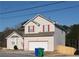 Charming two-story home features a large garage, neutral siding, red window trim, and a well-maintained yard at 5546 Wellborn Creek Dr, Lithonia, GA 30058