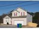 Two story home with vinyl siding, a garage and red trim highlights at 5546 Wellborn Creek Dr, Lithonia, GA 30058