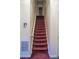 A carpeted staircase with white handrails and walls leads to the second story at 5546 Wellborn Creek Dr, Lithonia, GA 30058