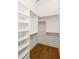 Walk-in closet featuring built-in shelving and wood floors for ample storage at 1235 Lupo Loop, Palmetto, GA 30268