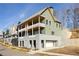 Modern exterior elevation view featuring multiple balconies and a two-car garage in a green and gray color scheme at 1235 Lupo Loop, Palmetto, GA 30268