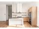Modern kitchen featuring a large island, stainless steel appliances, light wood cabinets, and natural light at 1235 Lupo Loop, Palmetto, GA 30268