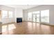 Bright living room featuring hardwood floors, a fireplace, large windows, and a sliding glass door to the balcony at 1235 Lupo Loop, Palmetto, GA 30268