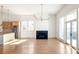 Bright open-concept living room with hardwood floors, fireplace, modern lighting, and a view of the kitchen and outdoor patio at 1235 Lupo Loop, Palmetto, GA 30268