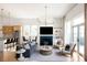 Cozy living room featuring a fireplace, modern chandelier, hardwood floors, sofa, chairs, and a view of the kitchen and dining area at 1235 Lupo Loop, Palmetto, GA 30268