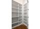 A large, well-organized walk-in pantry with wooden shelving, offers ample storage space at 1235 Lupo Loop, Palmetto, GA 30268