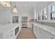 Bright kitchen with white cabinets, stainless steel appliances, quartz countertops, and modern fixtures at 343 Sugarview Rd, Sugar Hill, GA 30518