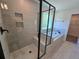 Modern tiled shower with a glass door and tub with views of the landscaped yard at 3677 Thornhill Ct, Douglasville, GA 30135