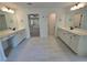Elegant bathroom featuring dual vanities with white cabinets and bright lighting at 3677 Thornhill Ct, Douglasville, GA 30135