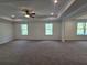 Spacious main bedroom featuring a tray ceiling, carpeted flooring, ceiling fan, and natural light at 3677 Thornhill Ct, Douglasville, GA 30135