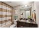 Updated bathroom with stylish vanity, decorative mirror, and a shower featuring a neutral-toned curtain at 1280 W Peachtree Nw St # 3414, Atlanta, GA 30309