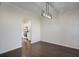 Spacious dining room with view into the kitchen, hardwood floors and modern light fixture at 902 Tree Creek Blvd # 2, Lawrenceville, GA 30043