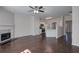 Open living room featuring hardwood floors, a ceiling fan, fireplace and seamless kitchen access at 902 Tree Creek Blvd # 2, Lawrenceville, GA 30043