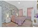 Cozy bedroom features a floral accent wall, pink bedding, and lots of natural light from the window at 138 Lakestone Pkwy, Woodstock, GA 30188