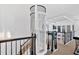 The second-floor landing includes a glass elevator that reaches to the other floors of the home at 138 Lakestone Pkwy, Woodstock, GA 30188