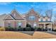 Stunning brick two-story home featuring mature landscaping and a covered front porch at 138 Lakestone Pkwy, Woodstock, GA 30188