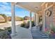 Covered front porch showcasing classic columns and an inviting entrance with tasteful decor at 138 Lakestone Pkwy, Woodstock, GA 30188