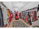 Walk-in closet featuring an array of shelves and hanging rods, complete with chandelier and zebra rug at 138 Lakestone Pkwy, Woodstock, GA 30188
