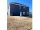 Backyard view of a two-story home with dark siding and well maintained backyard at 654 Egrets Lndg, Covington, GA 30014