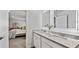 Bathroom featuring double vanity with granite top, framed mirror, and peek into the bedroom at 654 Egrets Lndg, Covington, GA 30014