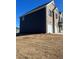 Rear side view of a two-story home featuring dark siding at 654 Egrets Lndg, Covington, GA 30014