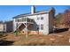 House's back exterior showcases a second-story porch, framed by a lush treeline with ladder on the ground at 7865 Lake Ter, Douglasville, GA 30134