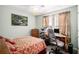 Functional bedroom featuring a workspace with a desk, chair, and comfortable bedding and natural light at 7865 Lake Ter, Douglasville, GA 30134